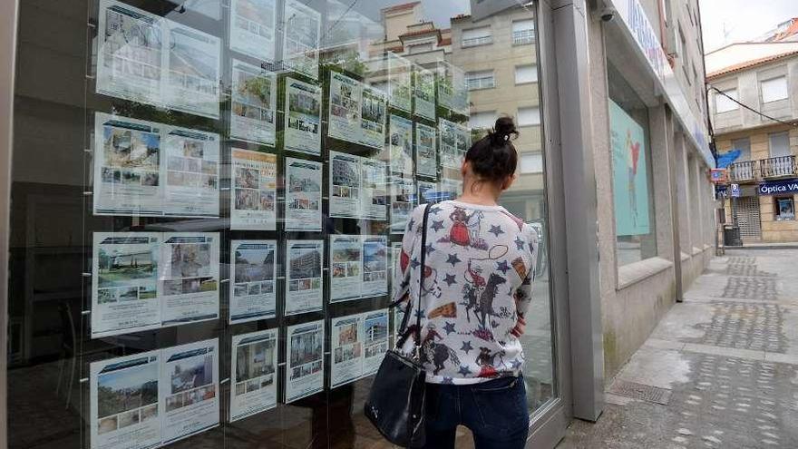 Una mujer lee anuncios de alquiler y venta de pisos.
