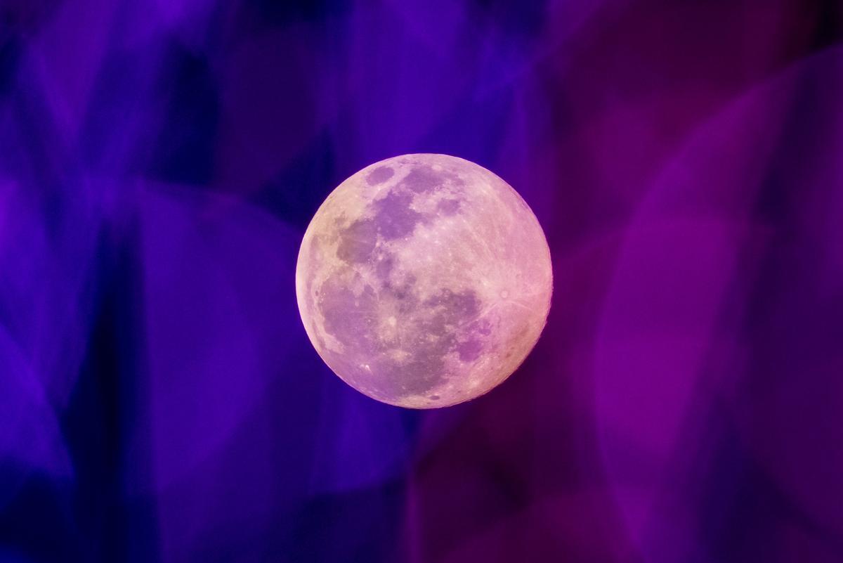 La luna del lobo, la primera luna llena del año, a través de luces de colores en Bangkok