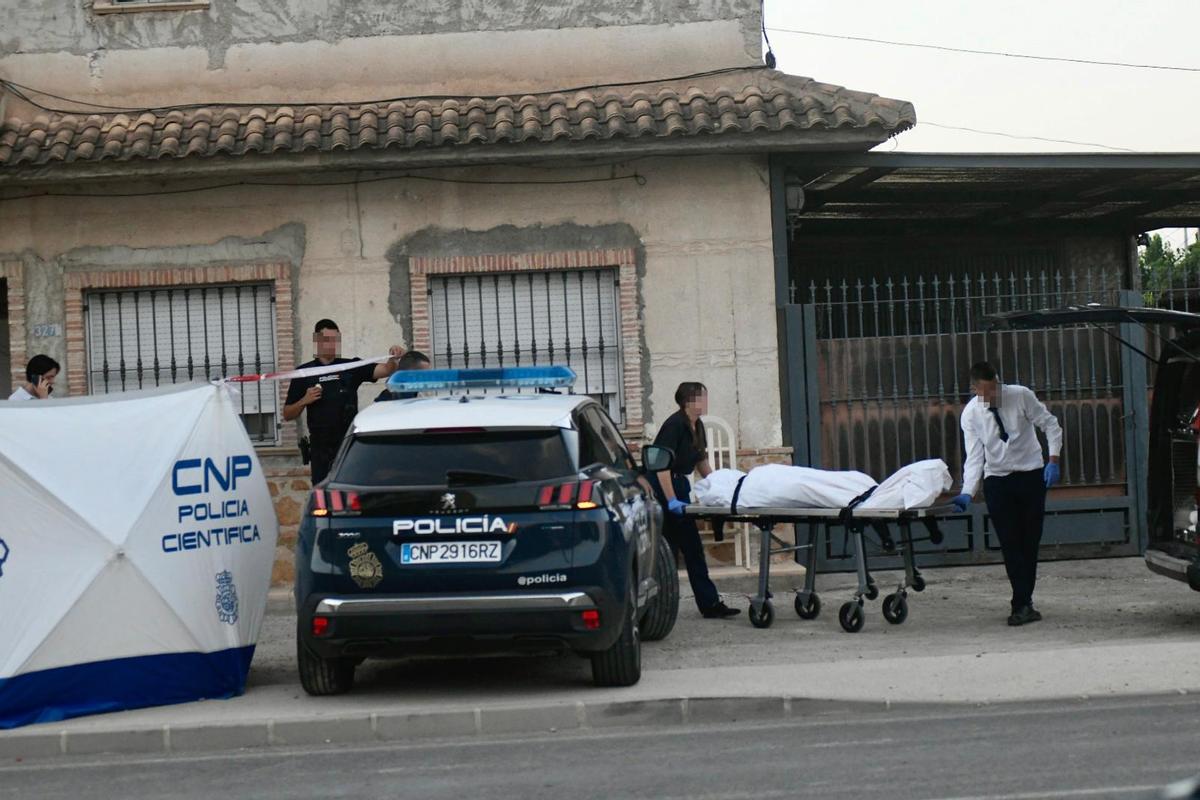 Efectivos sacan del domicilio el cuerpo de la víctima, esta tarde en el lugar de los hechos.