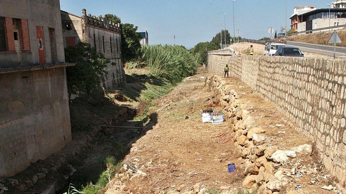 Un operario retira la vegetación que tapona con frecuencia un barranco muy encajonado. | VICENT M. PASTOR