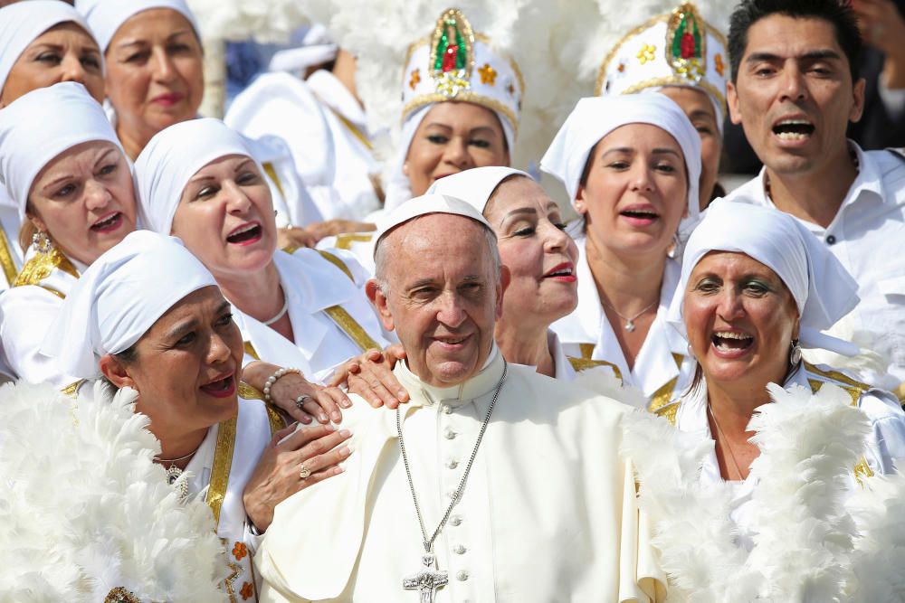 Pope Francis poses with a group of faithfuls ...