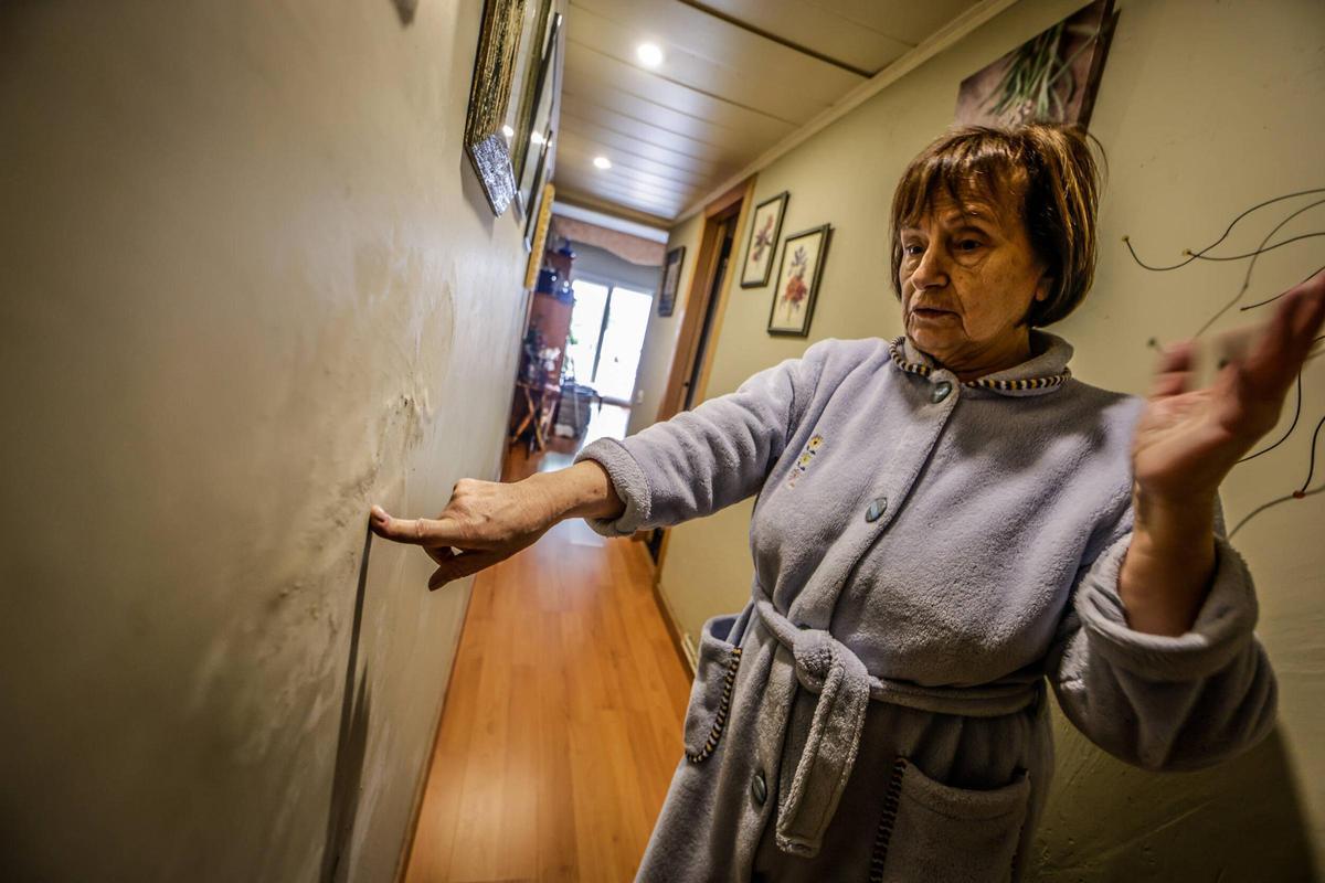 Ángeles muestra los daños en su vivienda provocados por la humedad que se filtra del edificio ruinoso del Poble-sec, en Barcelona.