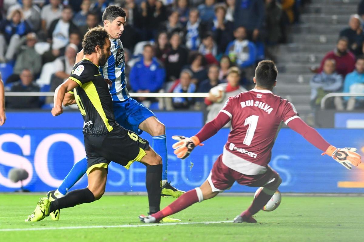 Carlos Fernández dispara ante Germán Sánchez y Rui Silva en el duelo contra el Granada en Riazor en 2018.