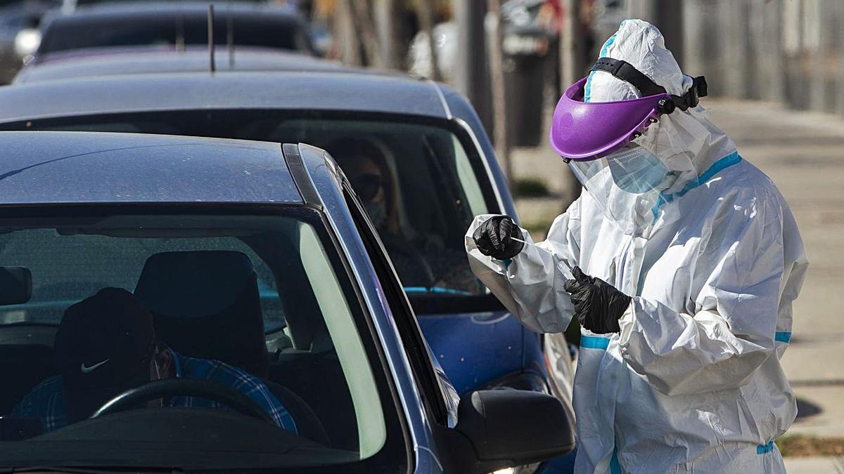 Un trabajador sanitario toma muestras para una prueba PCR a pacientes en La Fe, ayer.  | GERMÁN CABALLERO