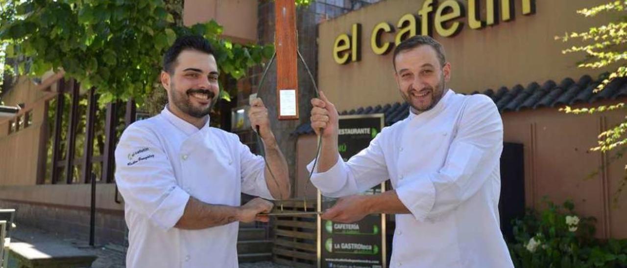 Rubén González y Sergio Orge, ayer ante El Cafetín de la Alameda, muestran el premio. // G. Santos