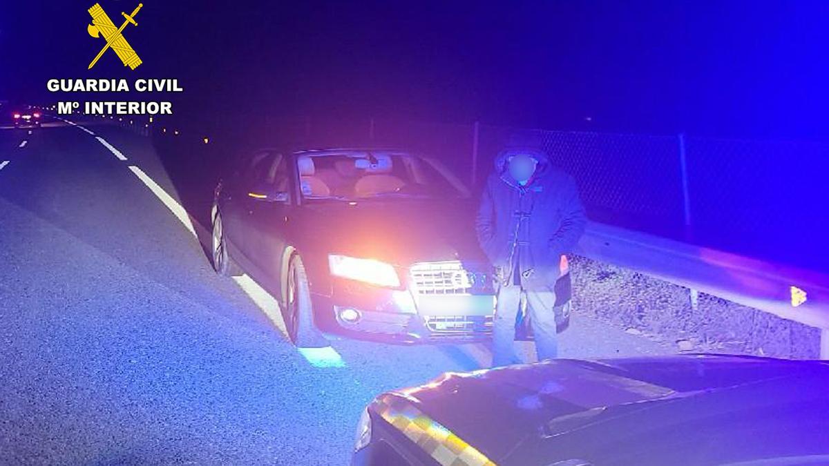 El detenido, junto a su coche.