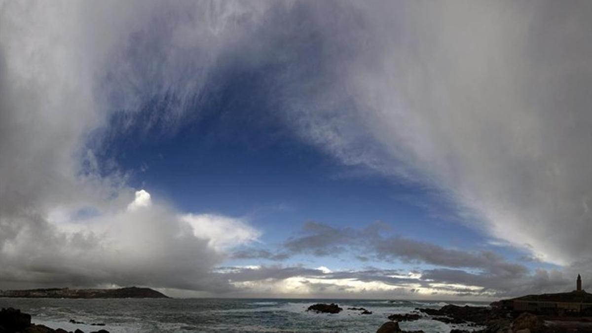 Las nubes cubren la Torre de Hércules en A Coruña, en una jornada marcada por la borrasca en Galicia y en la mayor parte de España.