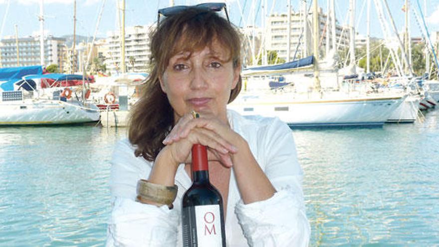 Joana Oliver Moragues sostiene, en el Club Naútico de Palma, una botella del vino premiado.