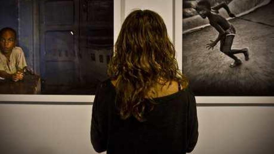 Una mujer observa dos de las fotografías de la muestra.