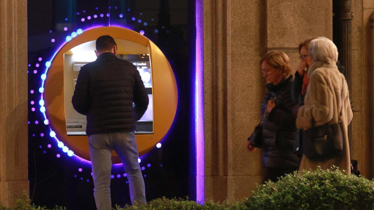 Un cliente usando el cajero de un banco en Vigo.