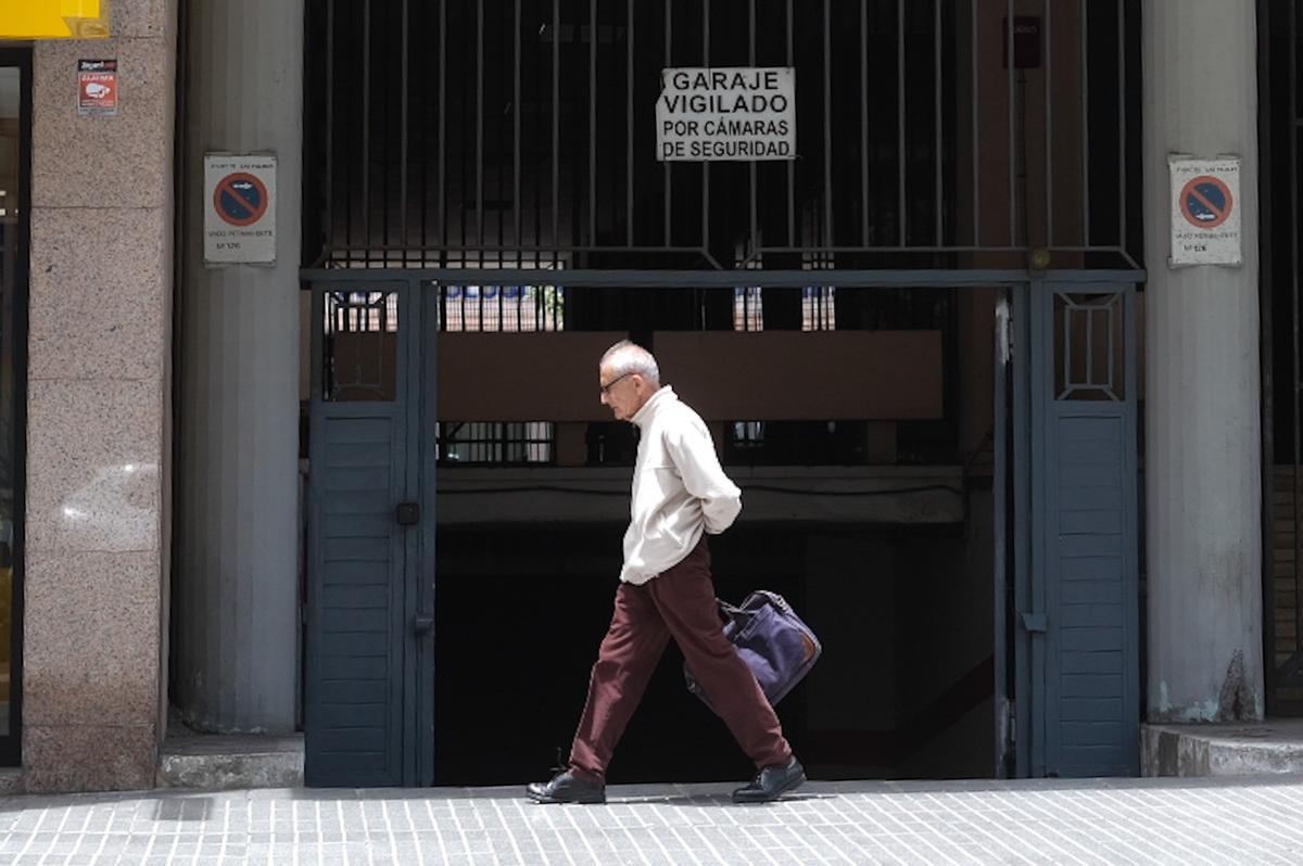 Un transeúnte  camina por delante de la puerta de un garaje.