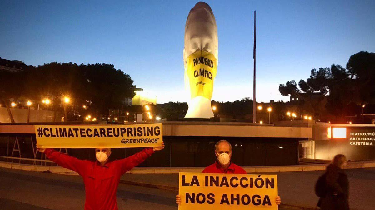 Greenpeace pone una mascarilla gigante a una estatua de la plaza de Colón de Madrid