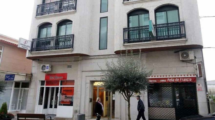 La peluquería del presunto asesino y la tienda de embutidos que regentaba la víctima están en los bajos de un mismo edificio de la calle Rosalía de Castro, en Arcade. // Marta G. Brea