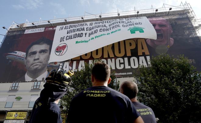 La colocación de una pancarta sobre la lona de Desokupa en Madrid, en imágenes