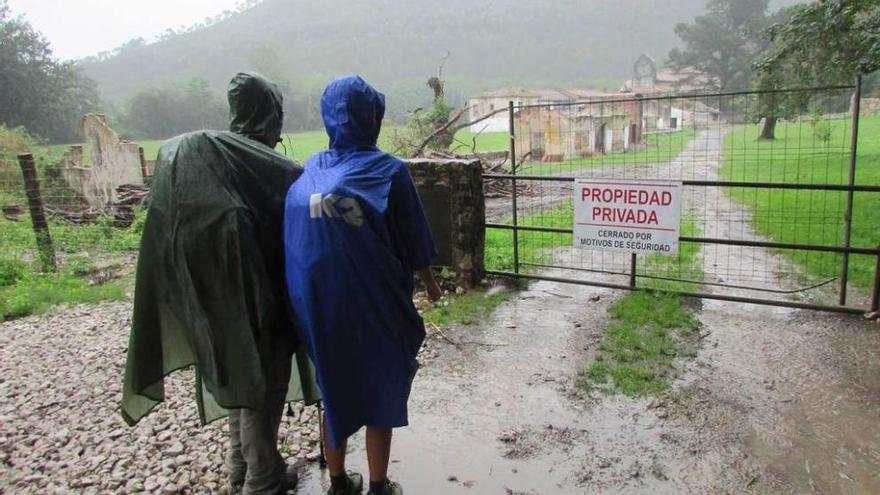 Dos peregrinos, ayer, junto a la entrada de la finca por la que se accede a la iglesia de Bedón, cerrada al público desde hace varias semanas.