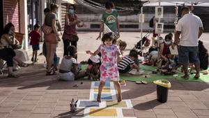 Una niña estrena la rayuela recién pintada en la plaza verde de Ciutat Meridiana, el complicado verano del 2020.