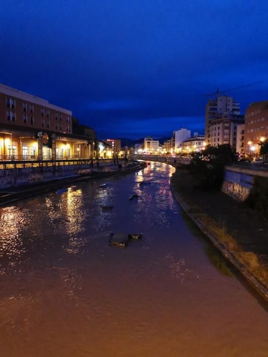 Inusual imagen, en Málaga capital, del cauce del Guadalmedina cubierto por el agua.
