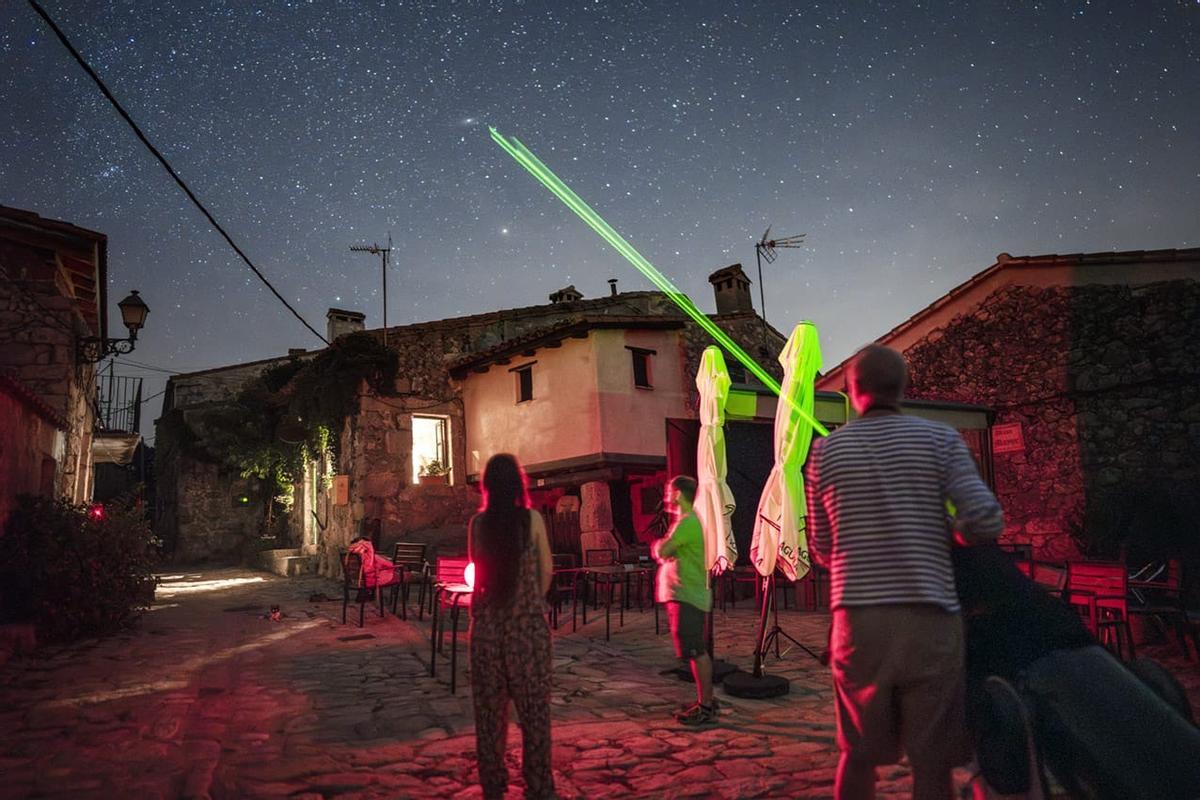 Daniel González y Nicolás Cahen señalan el cielo con un puntero láser
