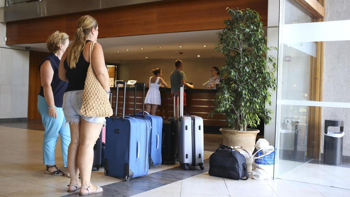 Turistas esperan frente a la recepción de un establecimiento en Benicàssim.