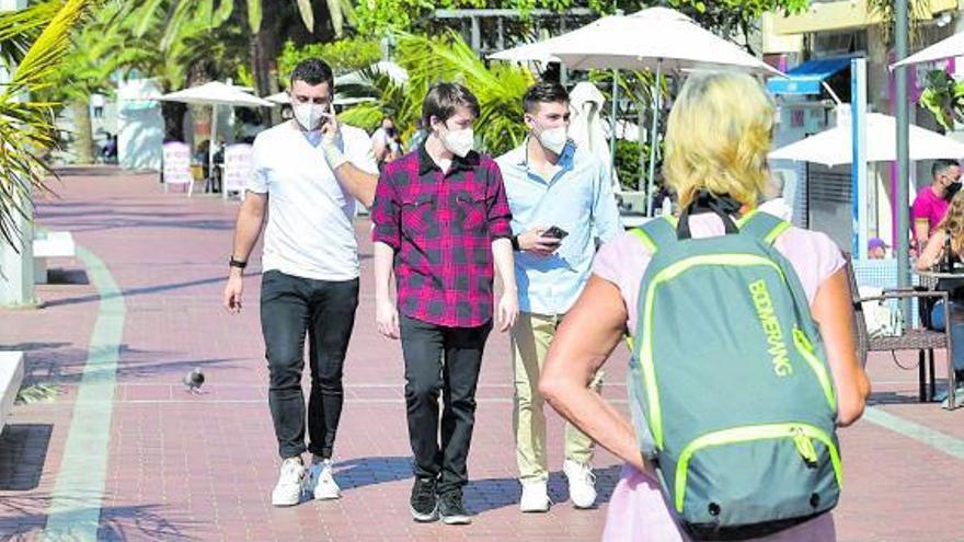 Tres jóvenes caminan con sus mascarillas durante la pandemia.