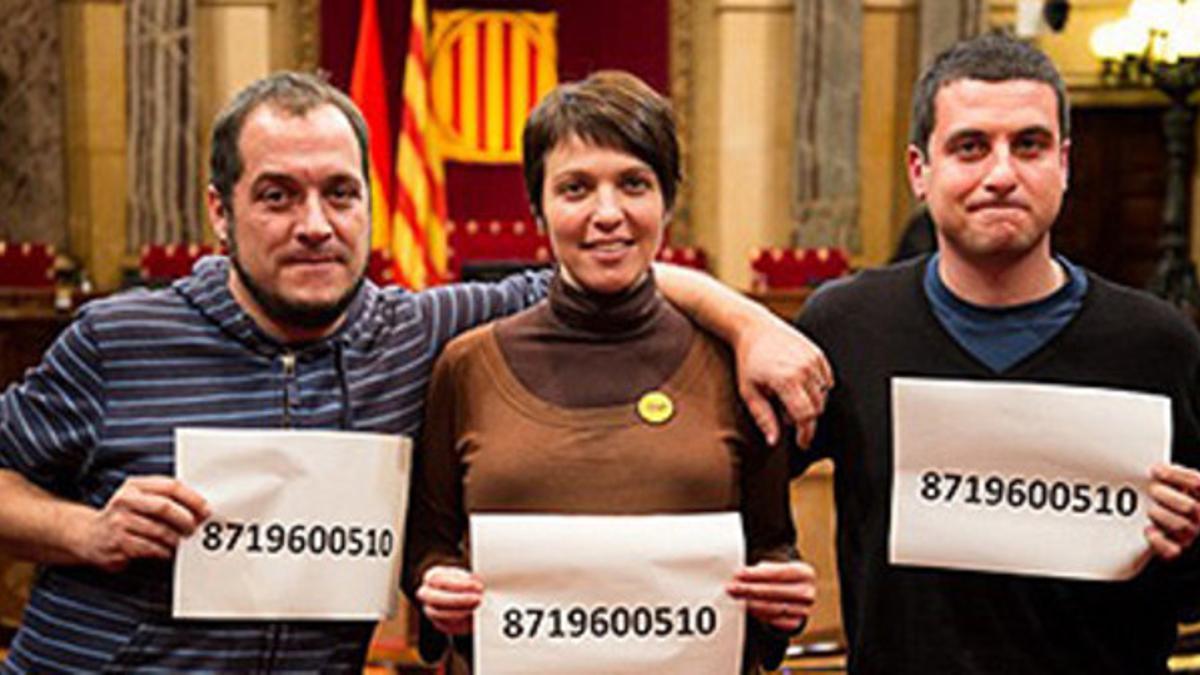 David Fernàndez, Georgina Rieradevall y Quim Arrufat muestran el número de preso de Otegi