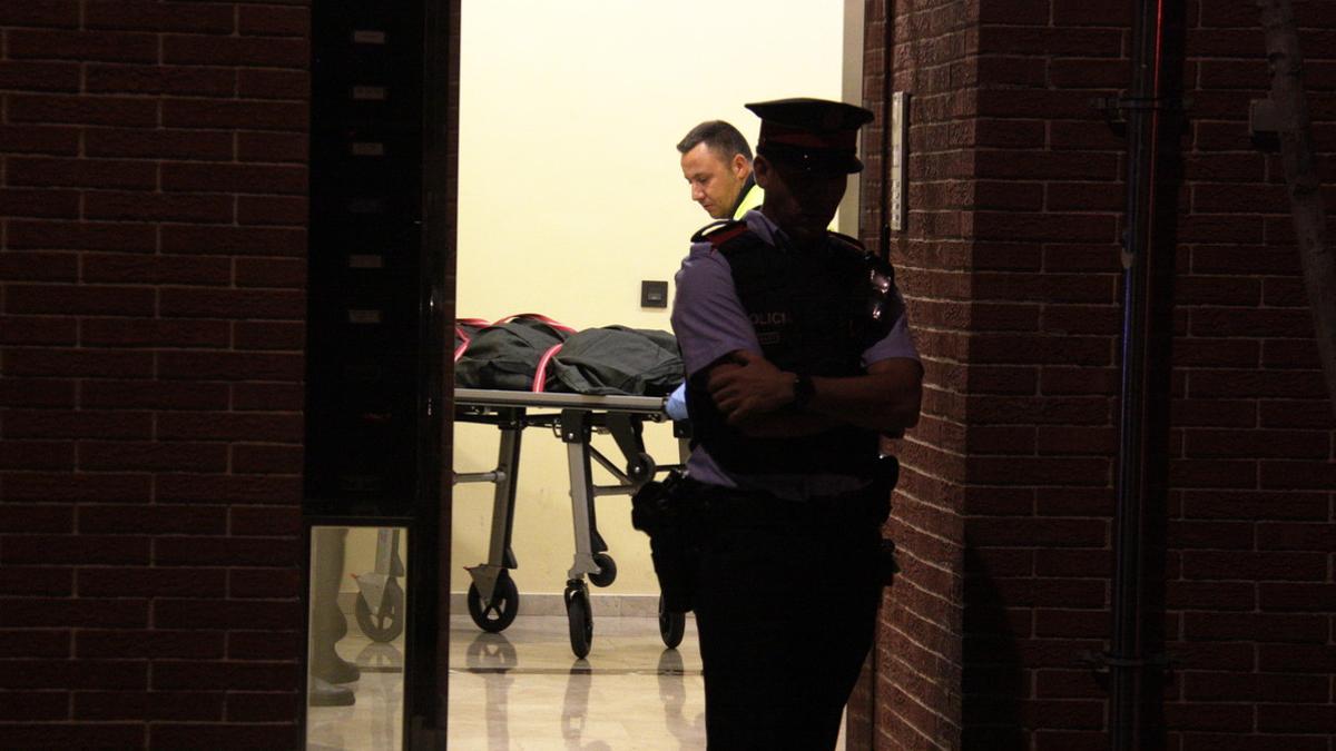 Los servicios funerarios retiran el cadáver de la mujer, en un edificio de la calle Francesc Layret de L'Hospitalet.