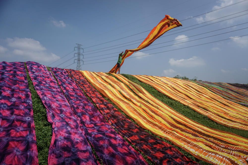 A worker throw a cloth during a drying process ...