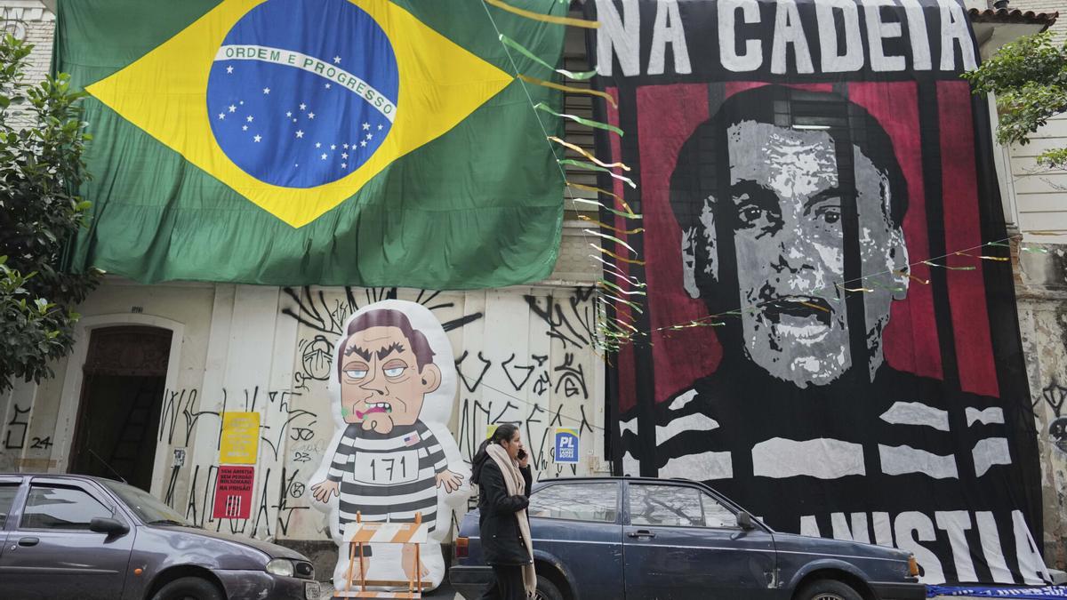Una mujer camina frente a un mural del expresidente, Jair Bolsonaro, entre rejas después de que el Supremo Tribunal Federal (STF) de Brasil le condenara a 27 años de cárcel por su papel en el intento de golpe de Estado de 2023.