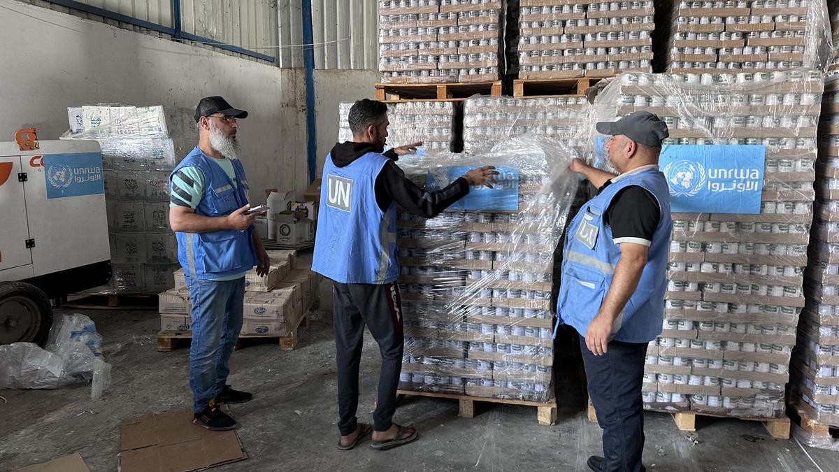 Trabajadores de la UNRWA distribuyen alimentos.
