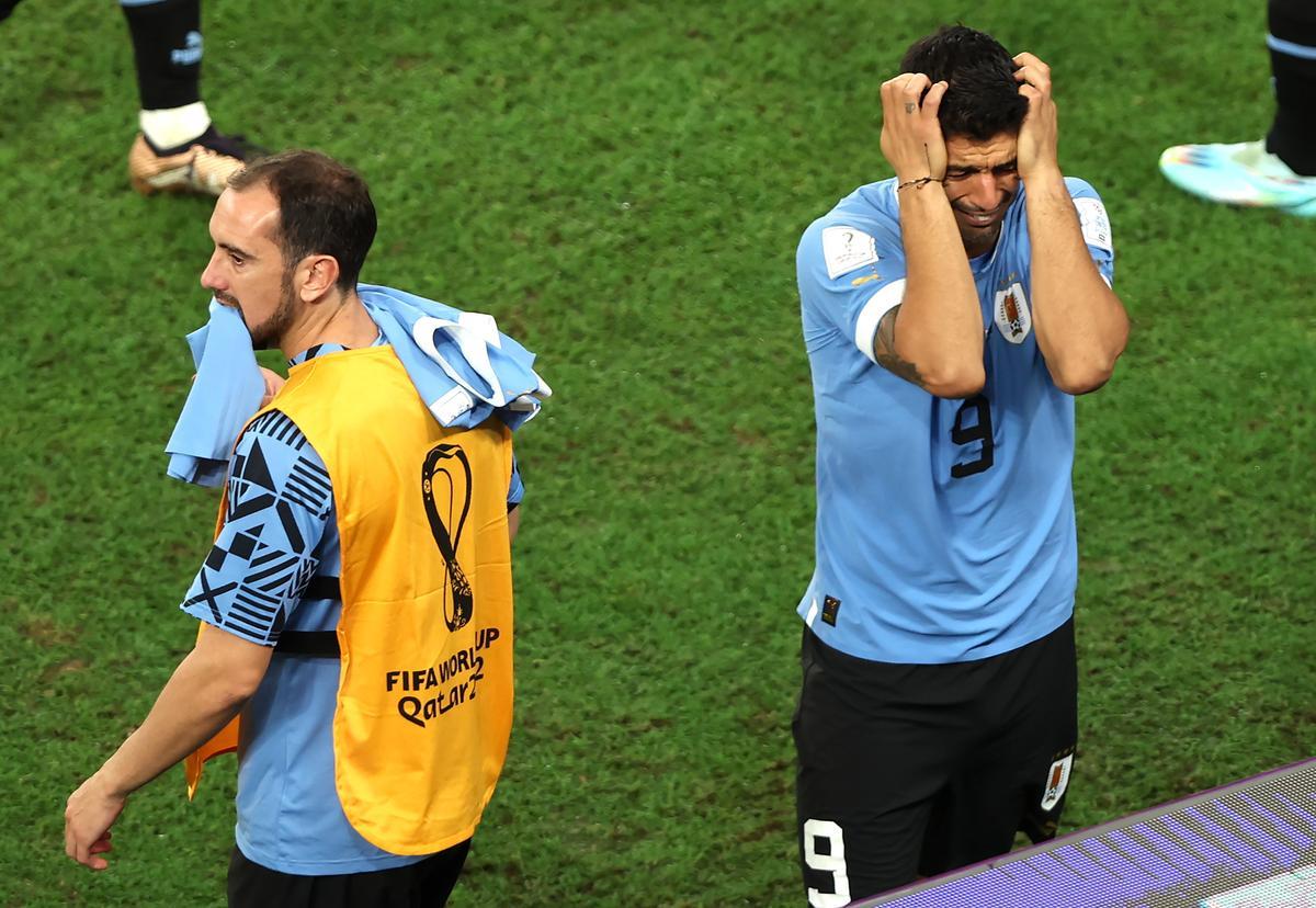 Godín y Suárez se lamentan tras la eliminación de Uruguay.