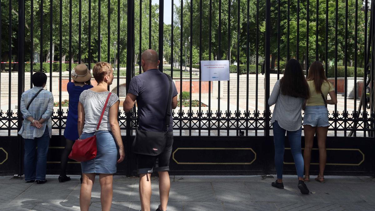 Un grupo de turistas observa El Retiro cerrado por rachas de viento, en 2018.