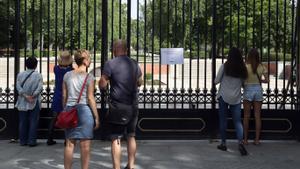 Un grupo de turistas observa El Retiro cerrado por rachas de viento, en 2018. 