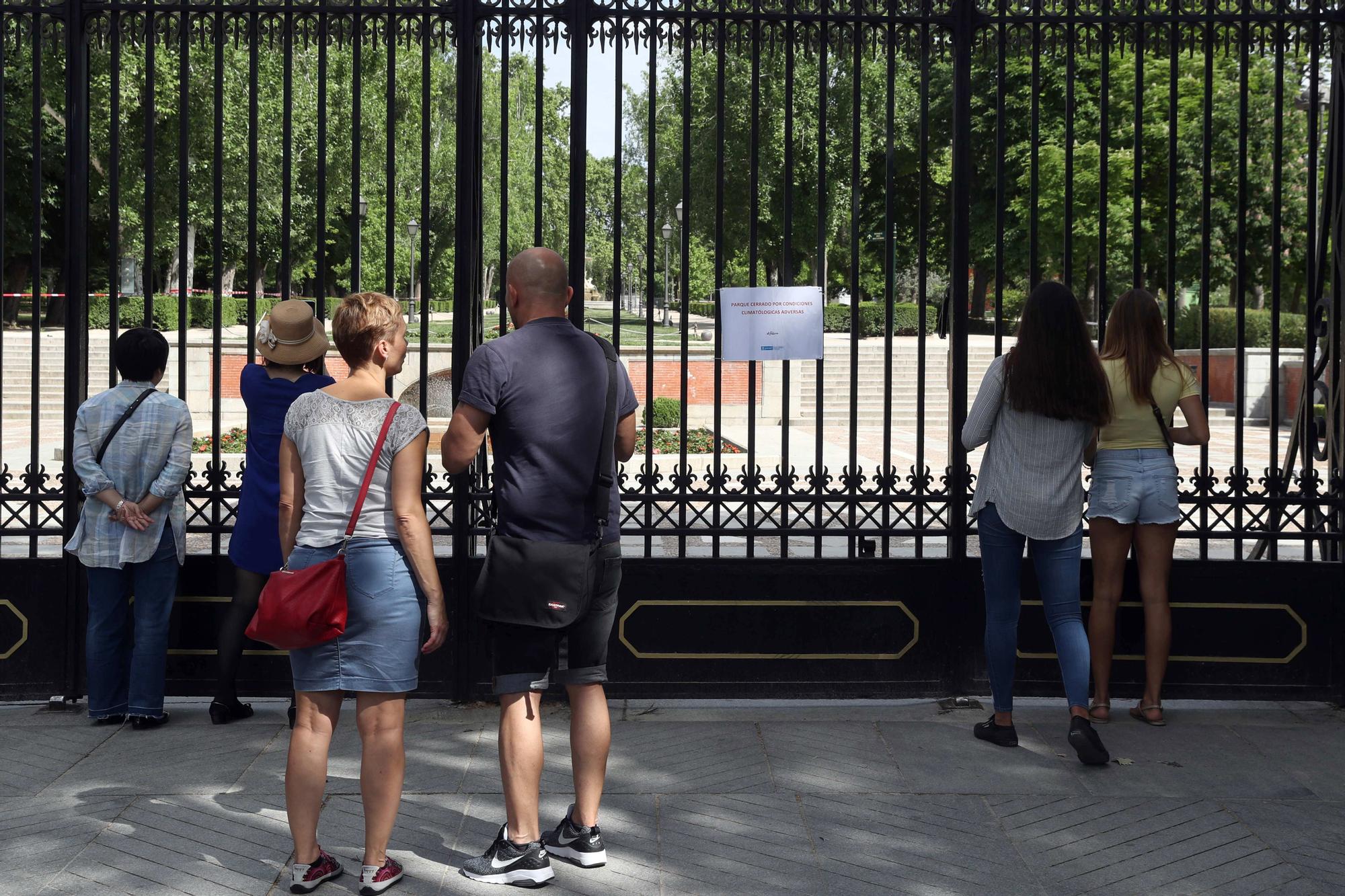 Un grupo de turistas observa El Retiro cerrado por rachas de viento, en 2018.