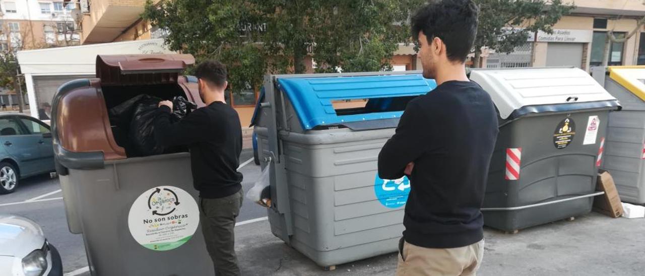 Un joven tira una bolsa de desechos al contenedor de restos orgánicos en San Vicente del Raspeig.