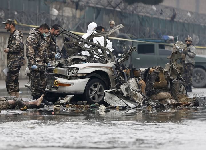 Afghan security forces investigate the wreckage of a vehicle used by suicide attack in Kabul