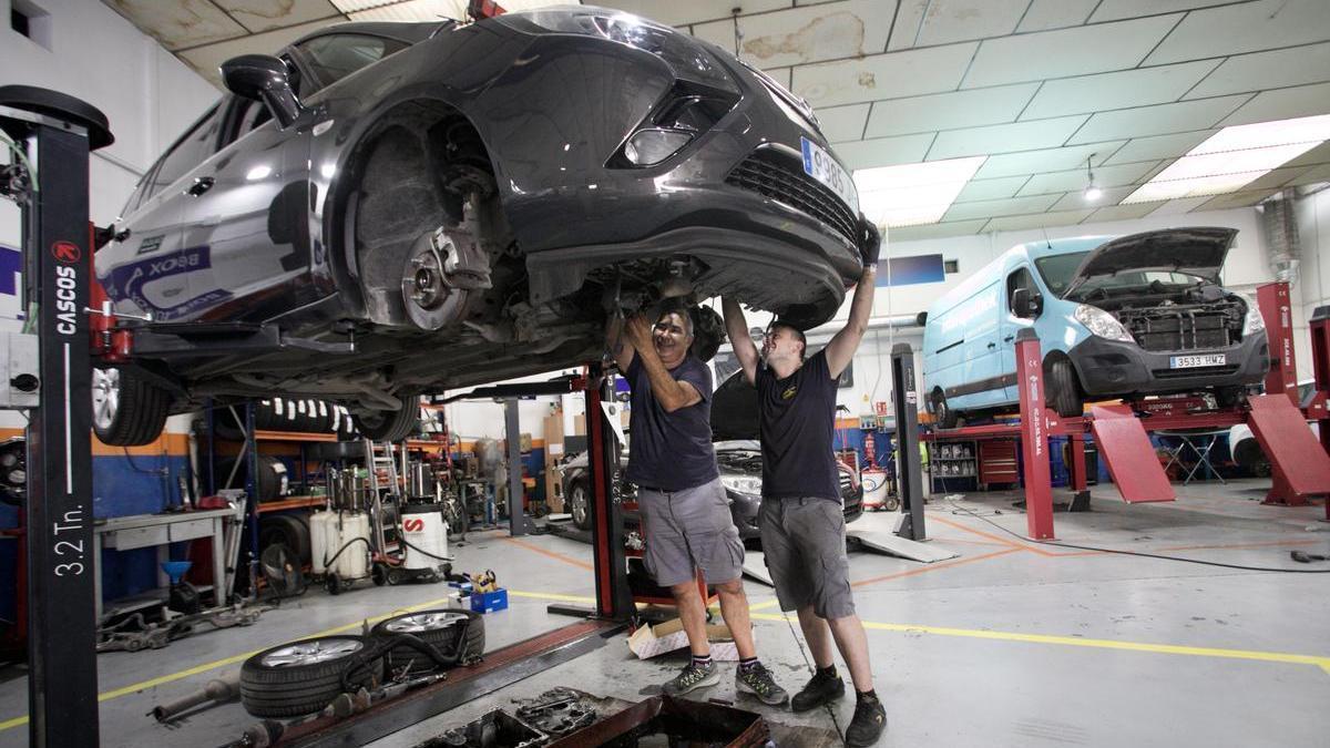 Trabajadores revisan un vehículo en un taller de Murcia