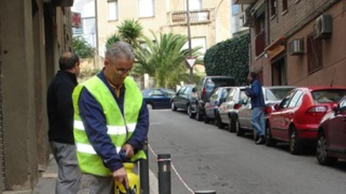 Un operario aplicando el líquido antideslizante en una calle de Santa Coloma de Gramenet.