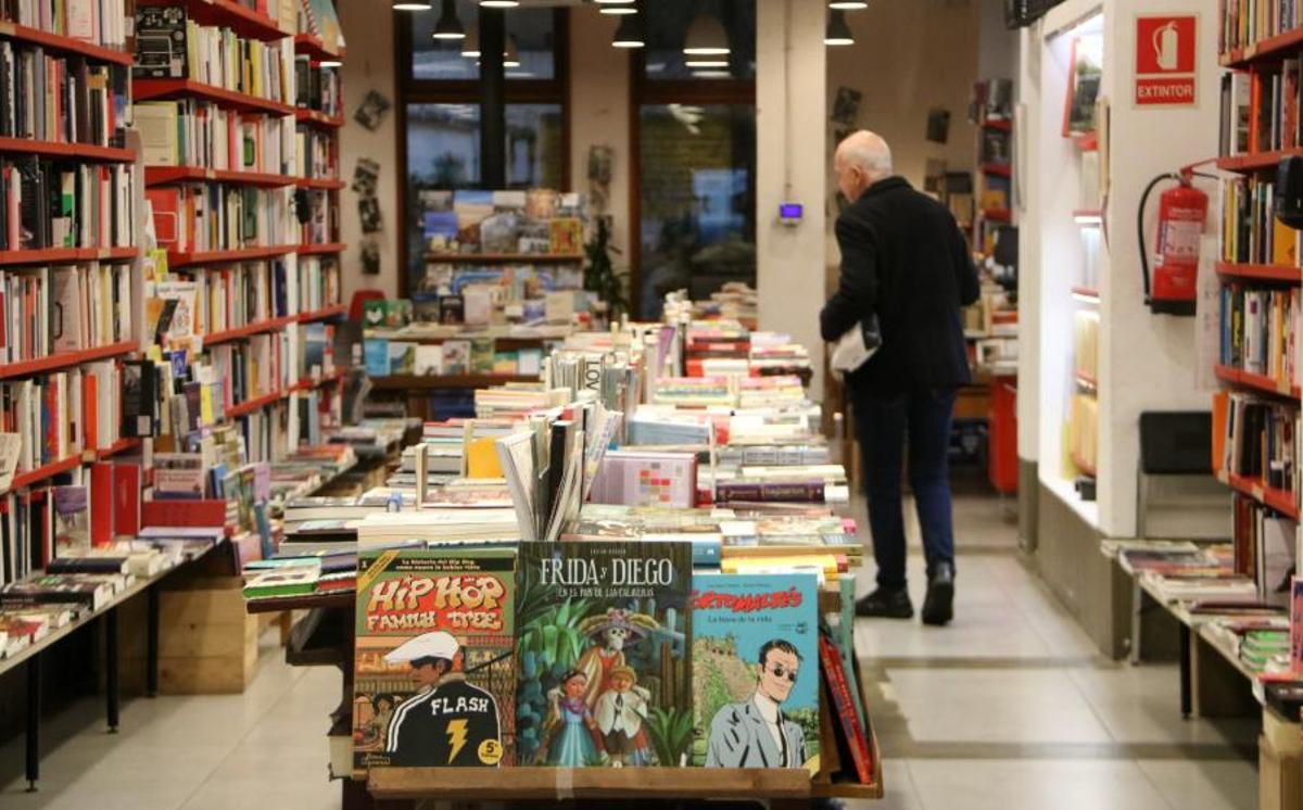 Una persona observant llibres a la llibreria Documenta de Barcelona