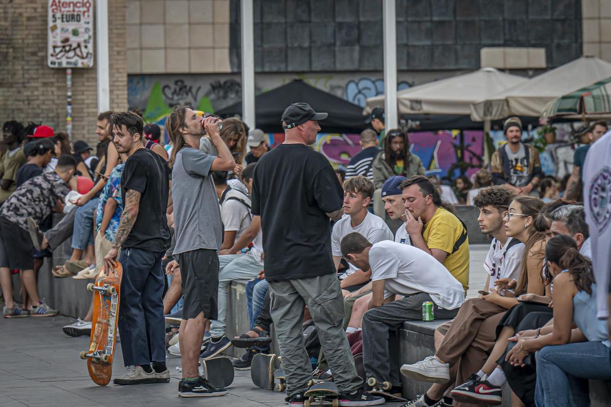 Jóvenes extranjeros en la plaza dels Àngels de Barcelona bebiendo cerveza en lata, pese a que está prohibido según la ordenanza de civismo