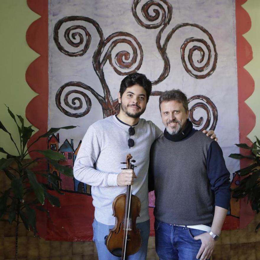 El violinista Daniel Arnaldo García, a la izquierda, con el profesor de música del colegio, Ramsés García.