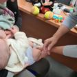 Una enfermera administra la vacuna de la tosferina a un bebé.