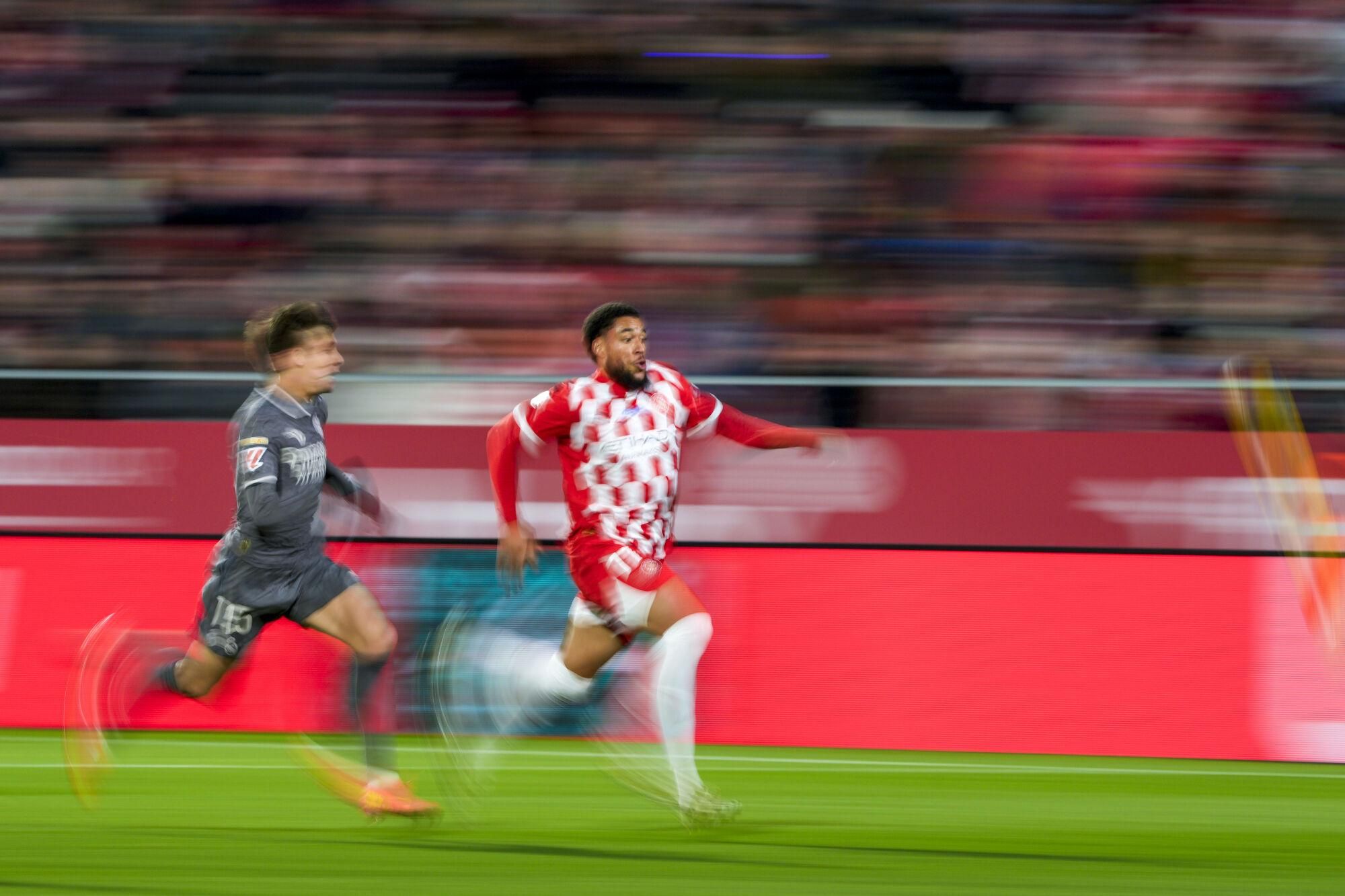 GIRONA, 07/12/2024.- El delantero neerlandés del Girona Arnaut Danjuma (d) persigue el balón con Arda Guler, del Real Madrid, durante el partido de la jornada 19 de LaLiga que Girona FC y Real Madrid disputan este sábado en el estadio Montilivi, en Girona. EFE/Alejandro García