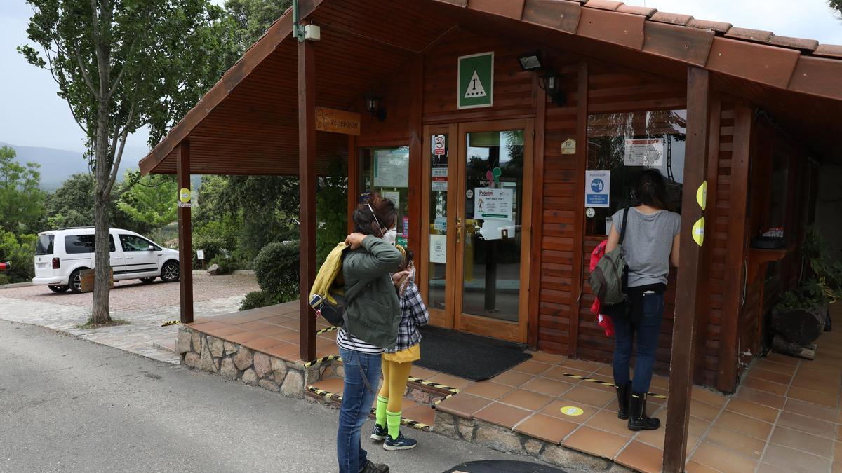 Varios clientes esperan en la recepción de un camping.