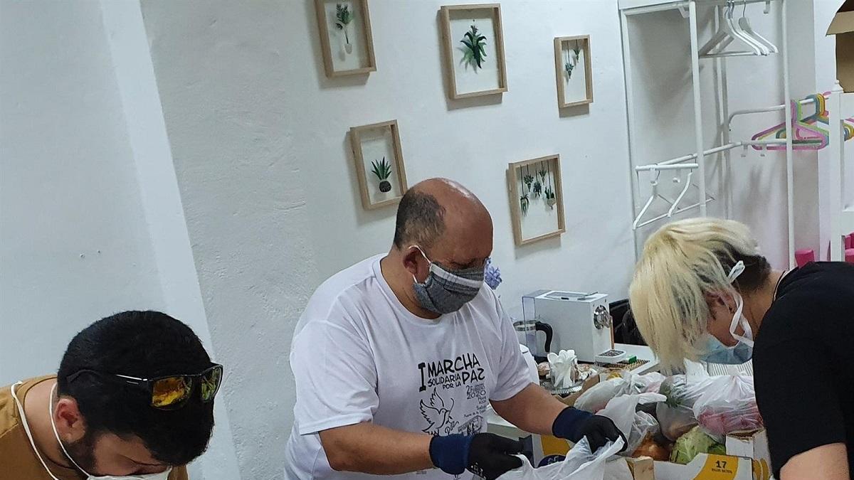 Voluntarios de Aspanoma preparan lotes de alimentos para familias de niños y niñas oncológicos de Málaga.