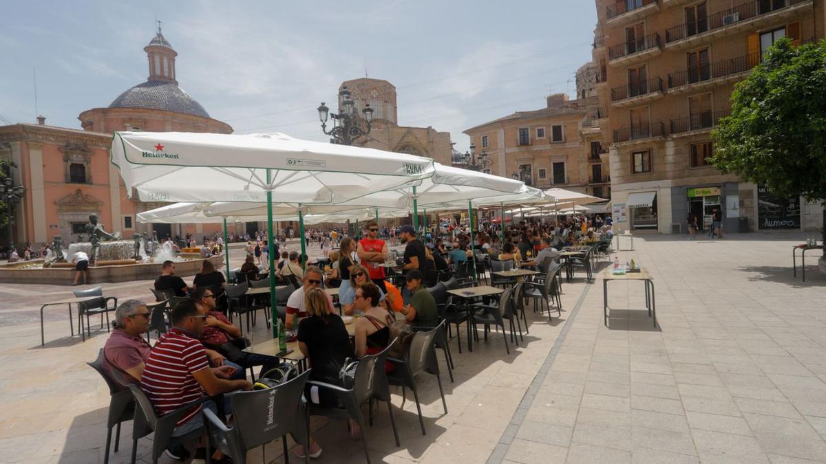 Clientes de una terraza de la plaza de la Virgen protegidos del sol, ayer al mediodía. | EDUARDO RIPOLL