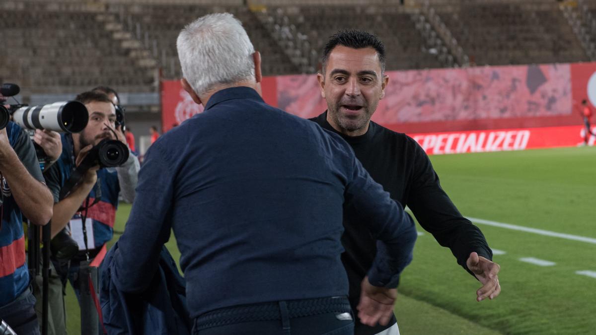 Xavi saluda a Javier Aguirre, el entrenador del Mallorca, antes de iniciarse el encuentro.