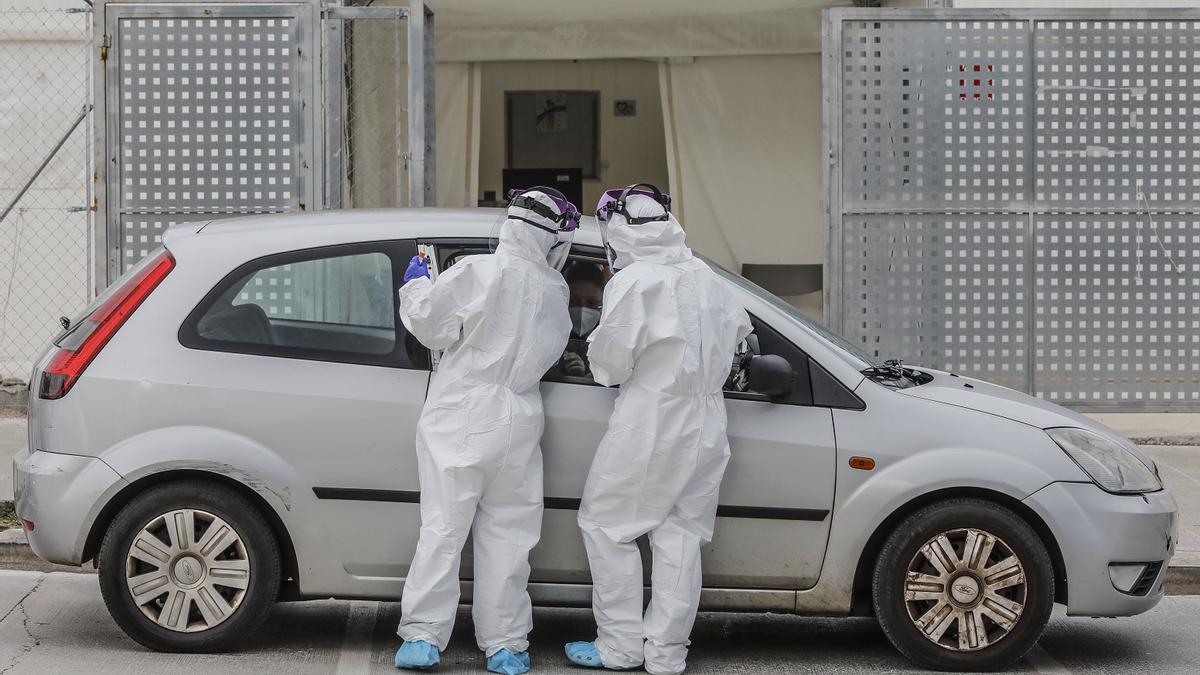 Archivo - Dos sanitarios realizan una prueba PCR