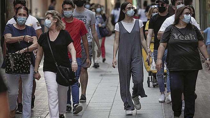 Paseantes con mascarillas en la calle Sant Miquel de Palma.