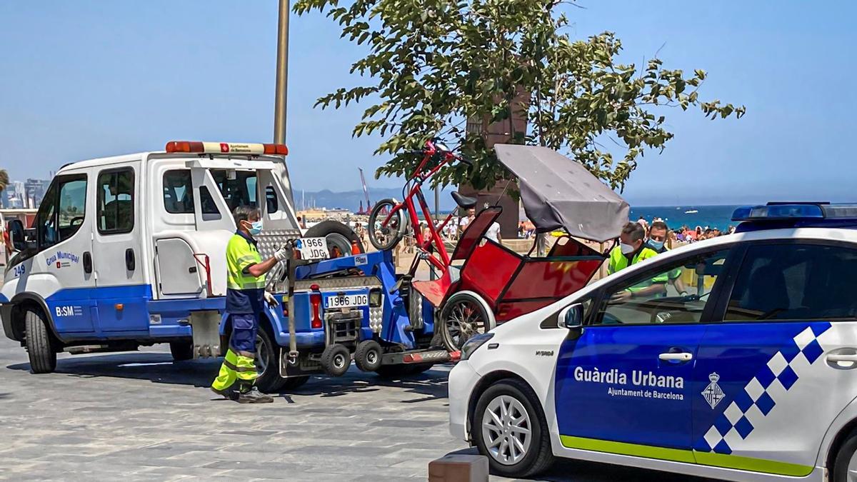 La grúa se lleva el bicitaxi del paquistaní Said, junto a la playa de Sant Miquel.