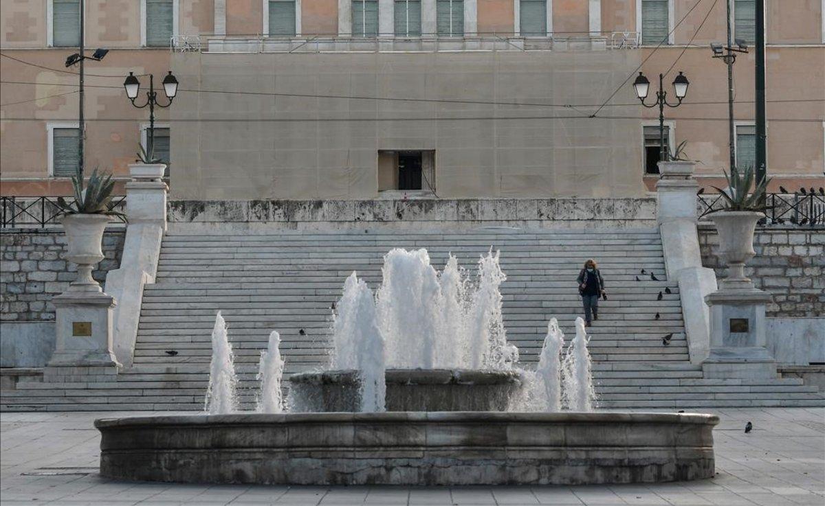 Una mujer, la única transeúnte de la plaza de Syntagma.